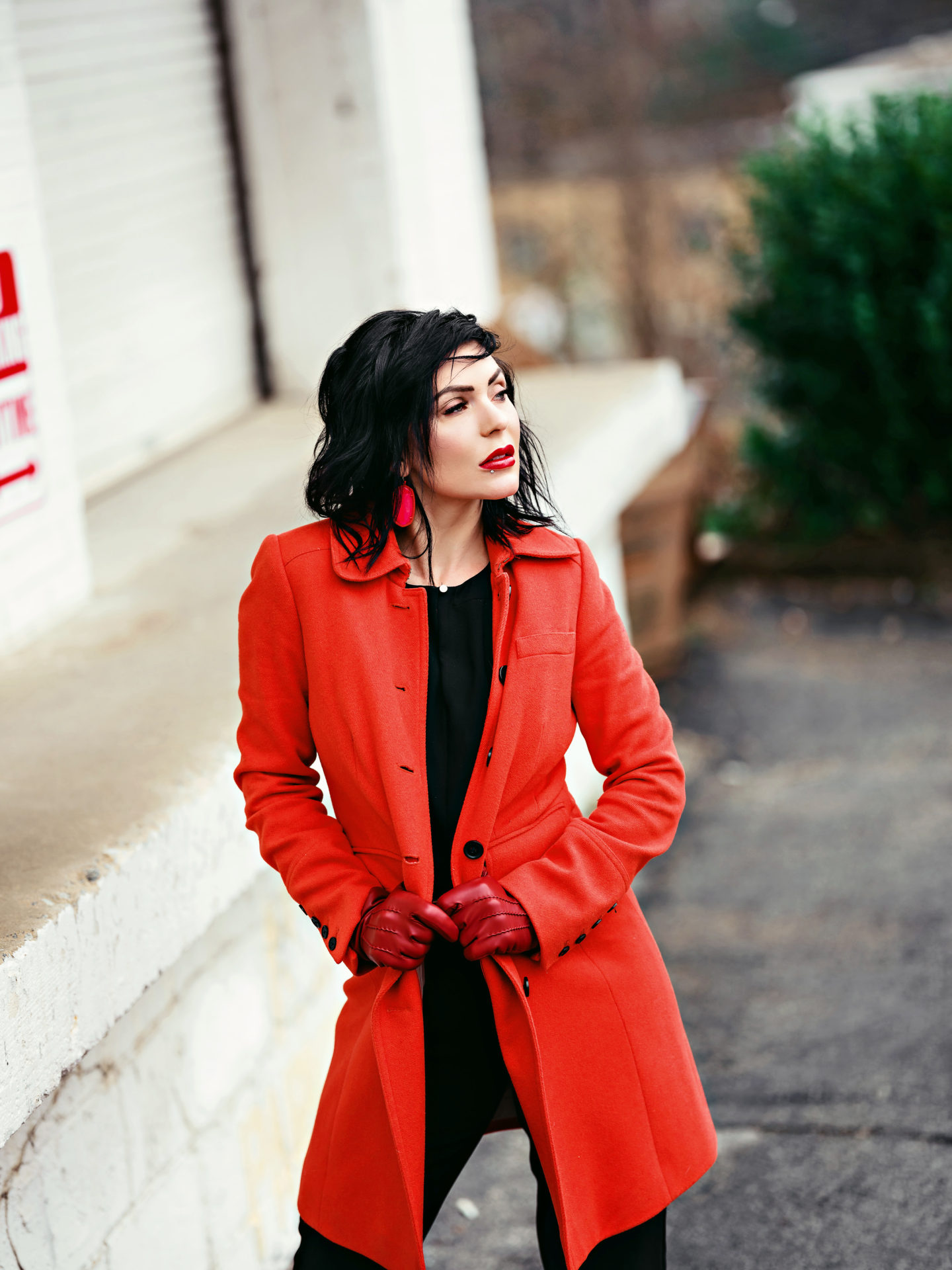 Stylish work outfits featured by top US fashion blogger, Chelissima: image of a woman wearing a red JCrew peacoat, black jumpsuit, Coach red leather gloves, and Kendra Scott jewelry